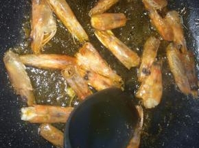 锅内倒入适量食用油，放入虾头，小火一边煎炸，一边用铲子按压虾头，直到油变成红色，虾头干瘪。