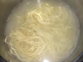 开水煮熟面条。