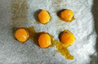 咸蛋黄提前用油浸泡一晚，喷白酒，预热烤箱160度烤8分钟。将咸蛋黄一分为二。因为我用的月饼模具是50克的，所以我每个月饼只放了半个咸蛋黄。