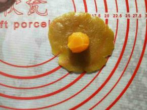 月饼馅和咸蛋黄称重，分为30克一份。将月饼馅揉圆按扁，放入咸蛋黄，包好揉圆备用。