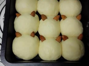 用剪刀在每个面团上剪两个口子，杏仁一头沾水，插在小口子上