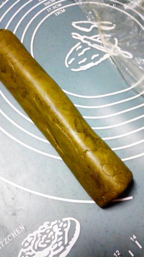 将剩余所有的抹茶面团，搓圆按扁成条状，完全包裹住之前做的熊猫胚，四面都要包住，包上保鲜膜，入冰箱冷冻30分钟