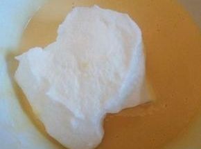 盛1/3蛋白到蛋黄碗里，翻拌均匀(从底部往上翻拌，不要画圈搅拌)