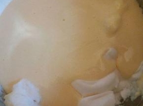 将拌匀的蛋黄糊倒入剩余的蛋白里，翻拌均匀，