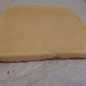 烤好的蛋糕震一下，连这油纸一起拿出来，趁热把油纸撒开，可以把油纸翻一个面再盖在上面，（不浪费）