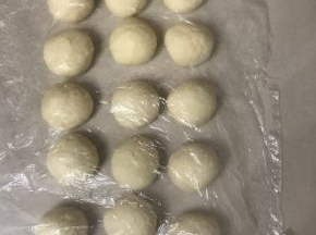 把松驰好的面团轻拍排气，分成15 份，滚圆盖上保鲜膜松弛10 分钟。