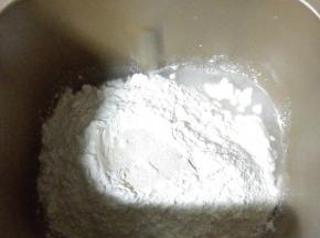 主料中除黄油外所有材料放入面包机中，顺序为：清水，糖，盐，披萨专用粉，酵母。