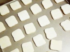 半小时后取出，稍微回温，用刀切成约5mm的薄片，放入烤盘