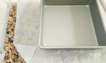 上面垫张油纸，拿一个小点的烤盘压在上面，使劲按压，尽量把燕麦压紧实