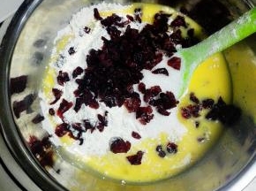 加入椰蓉，熟低粉，细砂糖，牛奶.再加入全蛋液,加入切碎的蔓越莓干