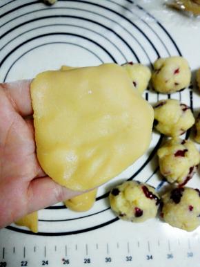 静置好的月饼皮，分成15克一个的小圆球，将月饼皮放在手掌，用另一只手压扁