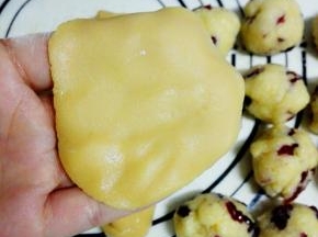 静置好的月饼皮，分成15克一个的小圆球，将月饼皮放在手掌，用另一只手压扁