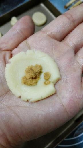 面团分成每个10克的小面团，搓圆，捏扁,中间放入适量肉松，包起来搓圆，注意露馅