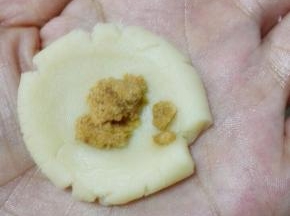 面团分成每个10克的小面团，搓圆，捏扁,中间放入适量肉松，包起来搓圆，注意露馅