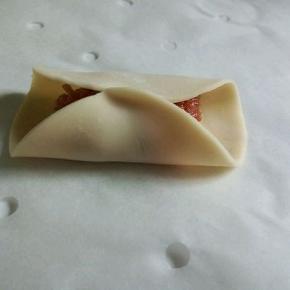 . 拿一张饺子皮，放上肉馅，对折，中间捏紧（皮干的话，可以沾点水）