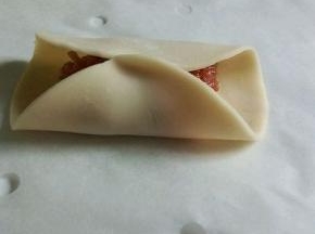 . 拿一张饺子皮，放上肉馅，对折，中间捏紧（皮干的话，可以沾点水）