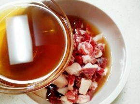 将料酒花椒水倒入羊肉丁碗中，拌匀，腌制1小时去膻味