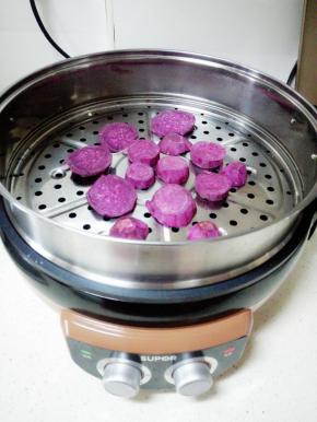 紫薯洗净去皮，切片，放入煎烤机隔水蒸8分钟