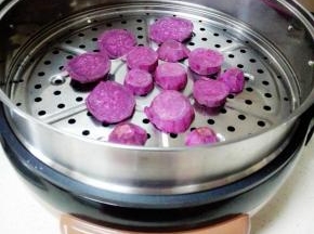 紫薯洗净去皮，切片，放入煎烤机隔水蒸8分钟