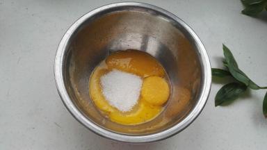 把白糖放入蛋黄中。