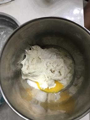 把发酵好的中种面团和主面团所有材料一起放入厨师机桶里，用厨师机二档和面
