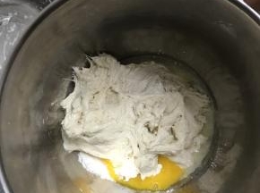 把发酵好的中种面团和主面团所有材料一起放入厨师机桶里，用厨师机二档和面