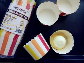 将拌好的面糊装入剪口的裱花袋，先在纸杯底部挤少许面糊，将剥好的鸡蛋竖立着放好