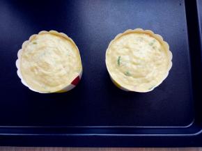 在鸡蛋周围挤满面糊，颠动几下震出气泡，至纸杯八九分满