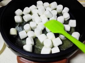 改小火，倒入棉花糖，慢慢搅拌至棉花糖和黄油融化在一起。