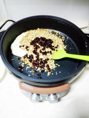 倒入碎花生米，蔓越莓干，关火，用手充分揉匀。 注意烫手