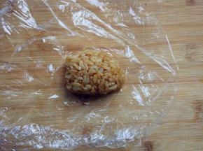 取适量酱油炒饭，放入保鲜膜中，捏出小鼠头部的形状