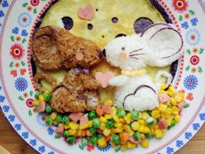 将一小段香肠用小刻刀切出心形，摆在两只小鼠之间，并为小鼠搓两条手臂，做出捧心的样子。用牙签在奶酪片上画小圆圈，然后用镊子将“珠子”摆在白色小鼠的颈部，做成项链。同时为另一只小鼠剪出颈部蝴蝶结就可以了