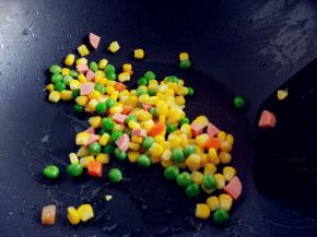 热锅热油，将什锦菜和切碎的香肠丁放入锅中，加少许盐翻炒均匀