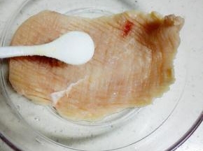 将放松好的两块鸡胸肉放入料理碗中，加入1茶匙盐，抹匀