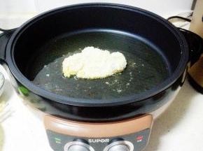 放入裹了面包糠的鸡胸肉，大火煎