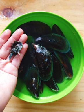 剥去青口周围的海草，再用铁丝或是牙刷刷青口背上的海草