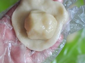 取一块油皮擀开，放上油酥包起滚圆。