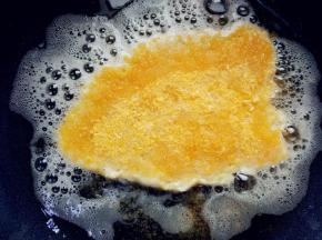 热锅热油，将油纸上的鸡排倒扣入锅中，撕掉油纸，表面洒适量面包糠，小火煎