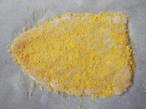 放在一张油纸上，将油纸对折后，擀成薄片，表面洒适量面包糠