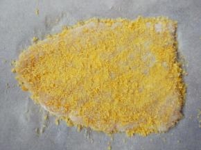 放在一张油纸上，将油纸对折后，擀成薄片，表面洒适量面包糠