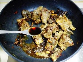 至羊蝎子表面微焦，放入生抽和老抽，翻炒至均匀上色