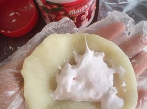 裹上一汤勺Fluff 草莓味棉花糖，将雪媚娘皮从四周向中间折叠，将棉花糖包裹住