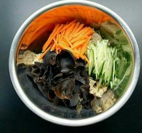 取一个大的容器。放入烤麸、黄瓜丝、胡萝卜丝、木耳