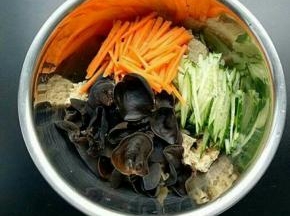 取一个大的容器。放入烤麸、黄瓜丝、胡萝卜丝、木耳
