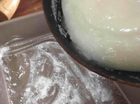 找一个大小合适的模具，刷一点水，撒上一层片粟粉（熟的太白粉，可以用作手粉，防粘。生的太白粉食用会中毒）。将熬好的求肥倒入。