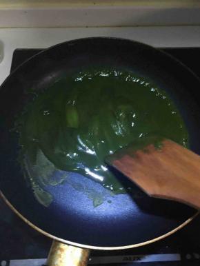 将过筛后的抹茶倒入白豆沙中，在不粘锅中进行炒制。炒到小山状即可。