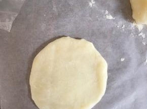 案板上撒些熟糯米粉防沾，取大概30克的面团擀开