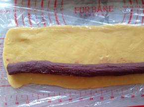 将冷藏后的面团擀成长方形，将馅料放在面片的一端。