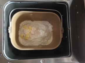 加入面粉和切成小块的黄油，在面粉顶端加入酵母，将面包桶放入到东菱面包机里