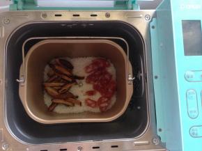 将菇和腊肠放在饭面上。